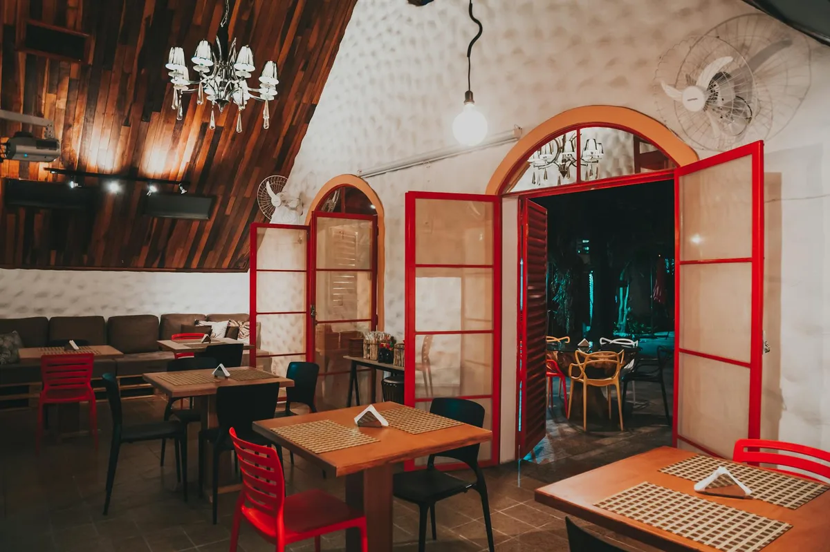 Warm and inviting restaurant interior featuring wooden details and red accents for a cozy atmosphere.